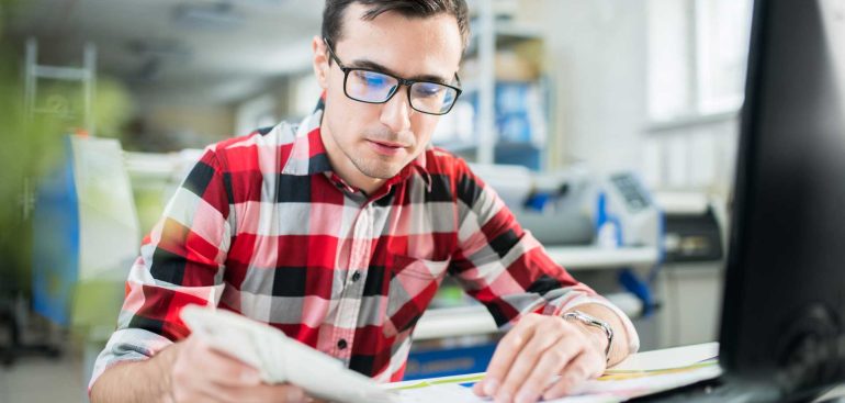 concentrated-designer-examining-quality-of-print-U4NWQDP.jpg